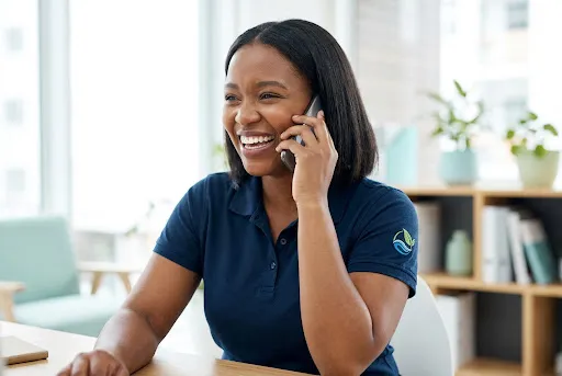 A friendly cleaning services representative speaking with a customer by phone.