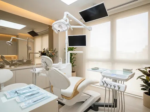 A meticulously clean, modern dental operatory with a patient chair and bright clinical lighting.