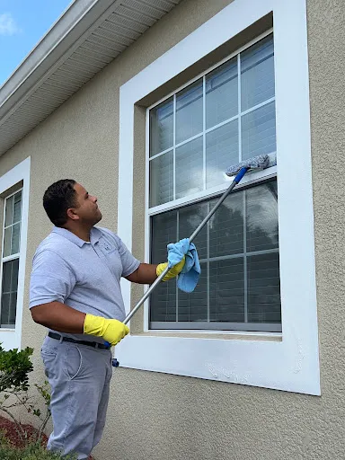 A professional cleaning the exterior windows of a commercial building.